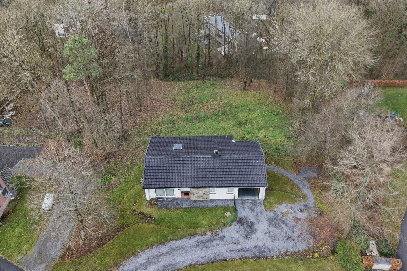 Vue aérienne par drone d'une maison individuelle avec grand terrain et environnement boisé, réalisée pour la valorisation immobilière par Immobilière Liberty.